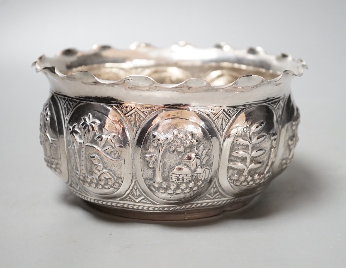 An Indian embossed white metal bowl, decorated with various scenes, diameter 16.5cm, 9oz.